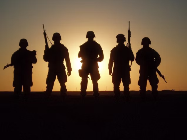 U.S. soldiers standing together, viewed from behind